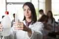 Scientific researcher holding a distilled purified deionised water in plastic bottles with a pump