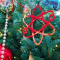 Scientific symbol of the atom as decoration at New Years celebration, golden bokeh. Winter christmas tree with bauble, copy space Royalty Free Stock Photo