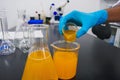Scientist adds yellow liquid for a chemistry experiment in a scientific research laboratory