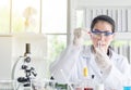 Scientist beautiful woman research and drop medical chemicals sample in test tube at lab Royalty Free Stock Photo