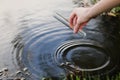 Scientist and biologist hydro-biologist takes water samples for analysis. Hand is collects water in a test tube. Pond