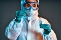 Scientist in chemical protective suit dripping reagent into test tube at laboratory