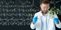 a scientist in a chemistry lab conducting a seedlings experiment with lab tools and a blackboard on background Royalty Free Stock Photo