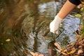 A scientist collects river water in a glass beaker