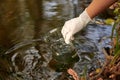 A scientist collects river water in a glass beaker