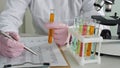 Scientist conducting experiments with test tubes and microscope in laboratory Royalty Free Stock Photo