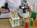Scientist conducting research with test tubes, microscope, and colorful solutions in a laboratory Royalty Free Stock Photo