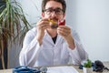 Scientist, doctor or medical professional holds in his hand laboratory test tube with blood and indicated positive result, in anot