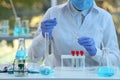 Scientist dripping sample into test tube in laboratory, closeup. Medical research