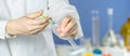 Scientist dropping chemical liquid to flask with lab glassware background, Laboratory research concept,Researcher is Royalty Free Stock Photo