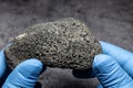 Scientist examines dark gray moon rocks up close Royalty Free Stock Photo