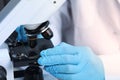 Scientist examining sample on slide under microscope, closeup Royalty Free Stock Photo