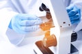 Scientist examining sample on slide under microscope at table, closeup Royalty Free Stock Photo