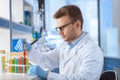 Scientist in eyeglasses working with test tubes in lab