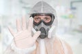 Scientist with FFP3 respirator mask is showing STOP gesture