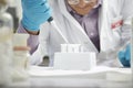 Scientist Filling Test Tubes With Pipette In Laboratory