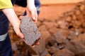 Scientist geologist hands inspecting exploration on iron ore rock on open field mine site Royalty Free Stock Photo