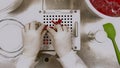 Scientist with gloves and lab coat making capsules in the laboratory