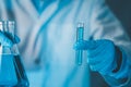 Scientist hand hold test tubes and erlenmeyer flask filled with blue sample chemicals in chemistry science laboratory. Glassware Royalty Free Stock Photo