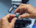 Scientist Handling Sample Under Microscope Laboratory Setting Royalty Free Stock Photo