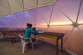 Scientist with his paper work in a dome tent sitting in front of