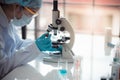 Scientist hold pipette adding fluid to test on microscope Royalty Free Stock Photo