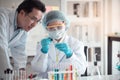 Scientist hold pipette adding fluid to test tubes or glassware Royalty Free Stock Photo