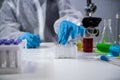 Scientist holding ampule with white powder, illegal pharmacy production, drugs. Laboratory assistant examines glass medical