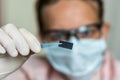 Scientist holding and examining damaged electrical chip Royalty Free Stock Photo