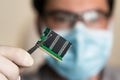 Scientist holding and examining damaged electrical component Royalty Free Stock Photo