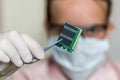 Scientist holding and examining damaged electrical component Royalty Free Stock Photo