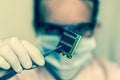 Scientist holding and examining damaged electrical component Royalty Free Stock Photo