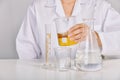 Scientist holding oil beaker, Laboratory and science experiments, Formulating the chemical for medical research