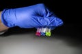 Scientist holding three colourful solution in different LCMS glass vial on a white bench with black background for medical Royalty Free Stock Photo