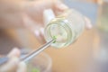 Scientist holding tongs for picking plant tissue culture in bottle, performing laboratory experiments. Small plant in test bottle