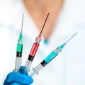 Scientist Holds Three Injection Filled with Green, Red, and Blue