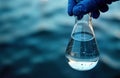 Scientist holds water sample flask. River water intake. Water quality testing. Eco research. Laboratory analysis. Potable water.