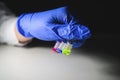 Scientist investigating three colourful solution in different LCMS glass vial on a white bench with black background for Royalty Free Stock Photo