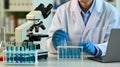 Scientist working in laboratory with microscope test tubes and laptop for research and development Royalty Free Stock Photo