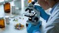 Scientist in laboratory examining sample under microscope developing new medicines and researching cures Royalty Free Stock Photo