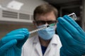 Coronavirus vaccine dose ready for immunisation. Doctor with gloved hands holding a hyperdermic needle and vaccination dose