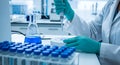 Scientist in laboratory wearing gloves performing precise liquid transfer using a pipette into a sample plate Background image Royalty Free Stock Photo