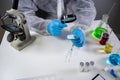 Scientist with magnifying glass. Covid-19 and the search for vaccine, chemist examines vial of coronavirus vaccine through