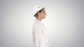 Scientist physicist woman walking in lab coat and hardhat on gradient background.