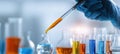 The scientist with a pipette adding colored liquids in laboratory flasks. AI generated image Royalty Free Stock Photo