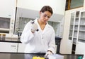 Scientist pouring a liquid in an Erlenmeyer flask