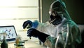 Scientist in ppe suits with test tubes working in laboratory