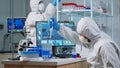 Scientist in protection suit using micropipette filling test tubes