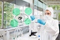 Scientist in protective suit working with green cell diagram int Royalty Free Stock Photo