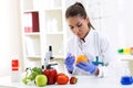 Scientist putting new sample to fruit and cheking results at clinic Royalty Free Stock Photo